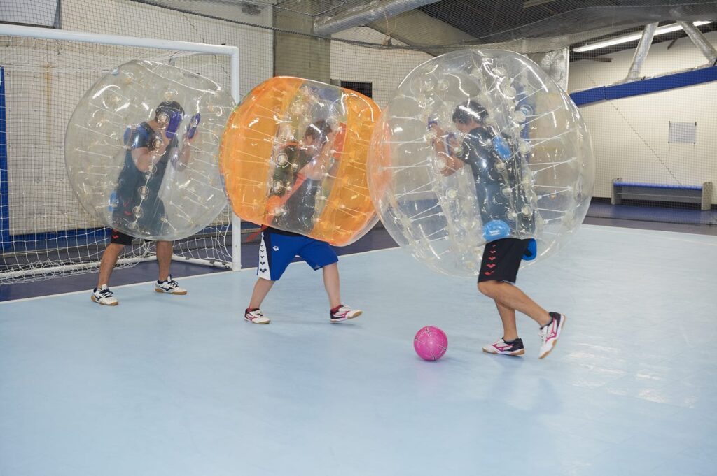 バブルボールを着用して、バブルサッカーを楽しむ若者たち